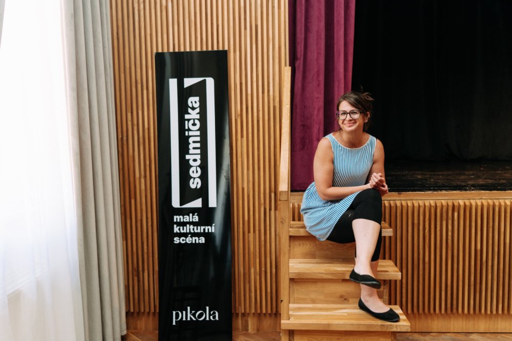 Eva Spilková sedí na schodech jeviště malé kulturní scény v Olomouci